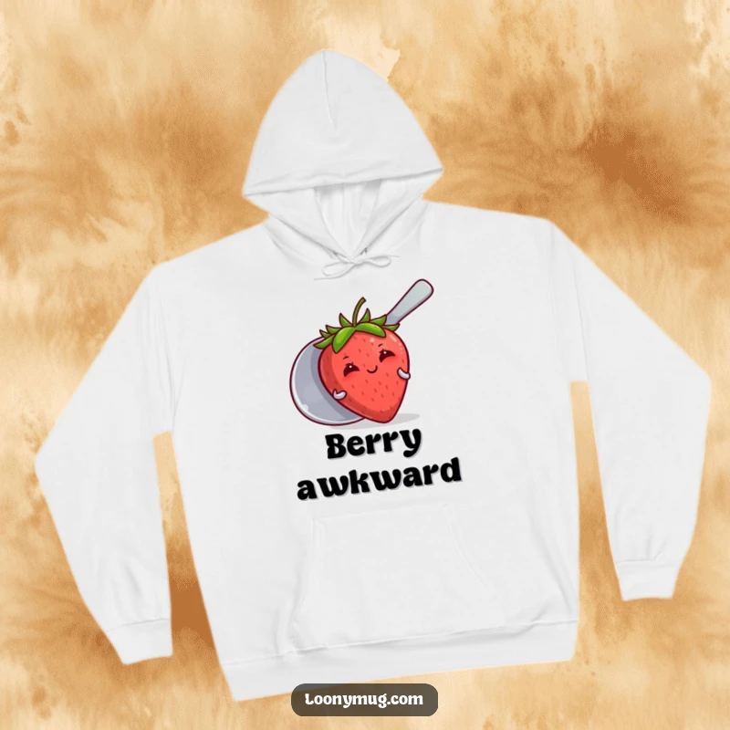 Funny hoodie showing a blushing strawberry peeking from behind a large spoon, radiating a shy and sweet vibe.