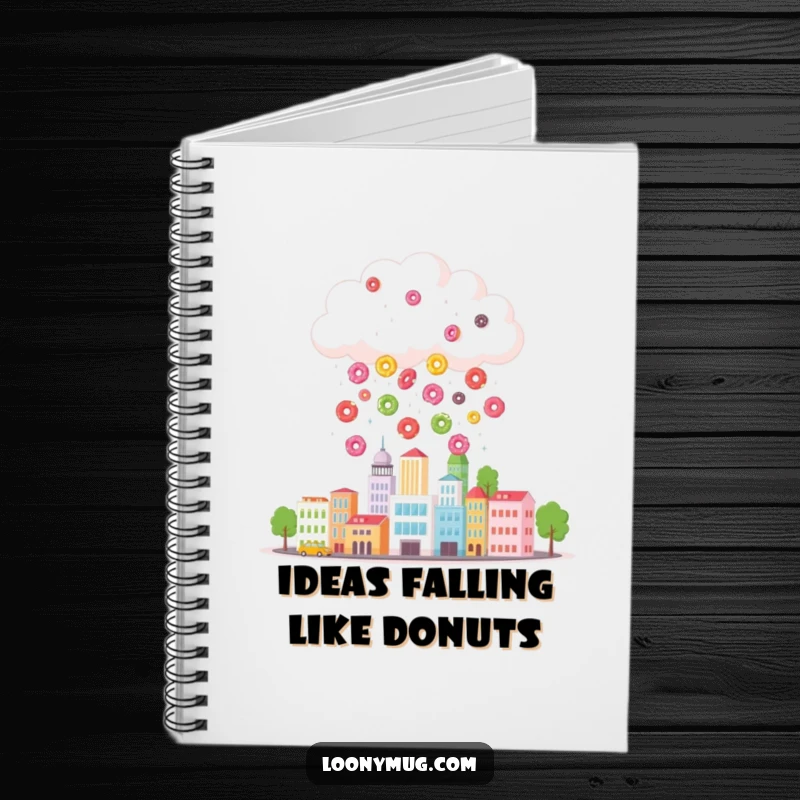 Funny notebook cover featuring a cloud raining colorful donuts onto a tiny cityscape, ideal for humorous note-taking and creative journaling.